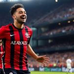 Miguel Almirón celebrating with teammates in Atlanta United jersey.