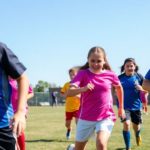 Youth soccer players in action on a sunny field.