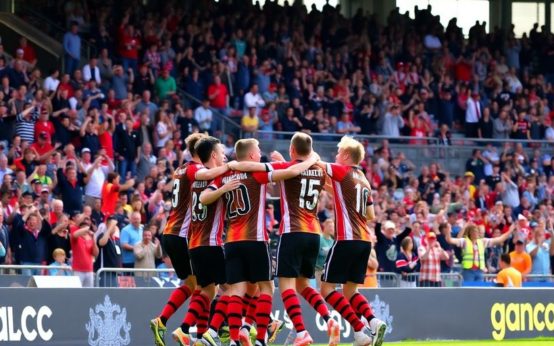 Jersey FC players celebrating a goal with fans.