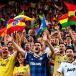 Excited soccer fans in jerseys at a stadium.
