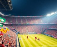 Soccer players in action during an MLS match with fans.